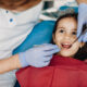 Close up of a cute little kid getting teeth checked by a pediatric dentist