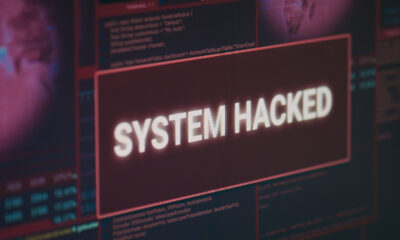 Computer monitor showing hacked system alert message flashing on screen